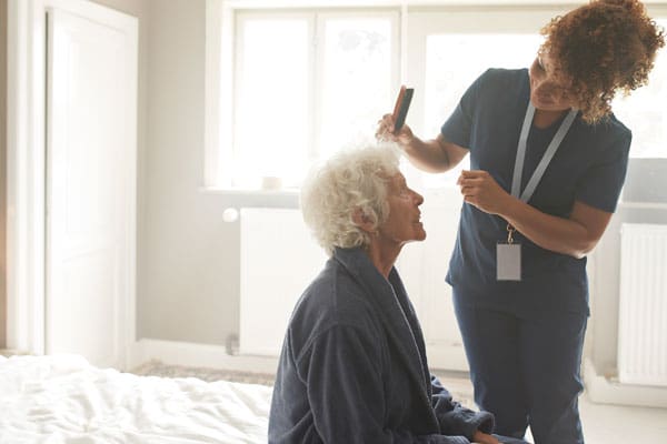 Caregiver helping with grooming at home | TLC Your Way Hospice Care