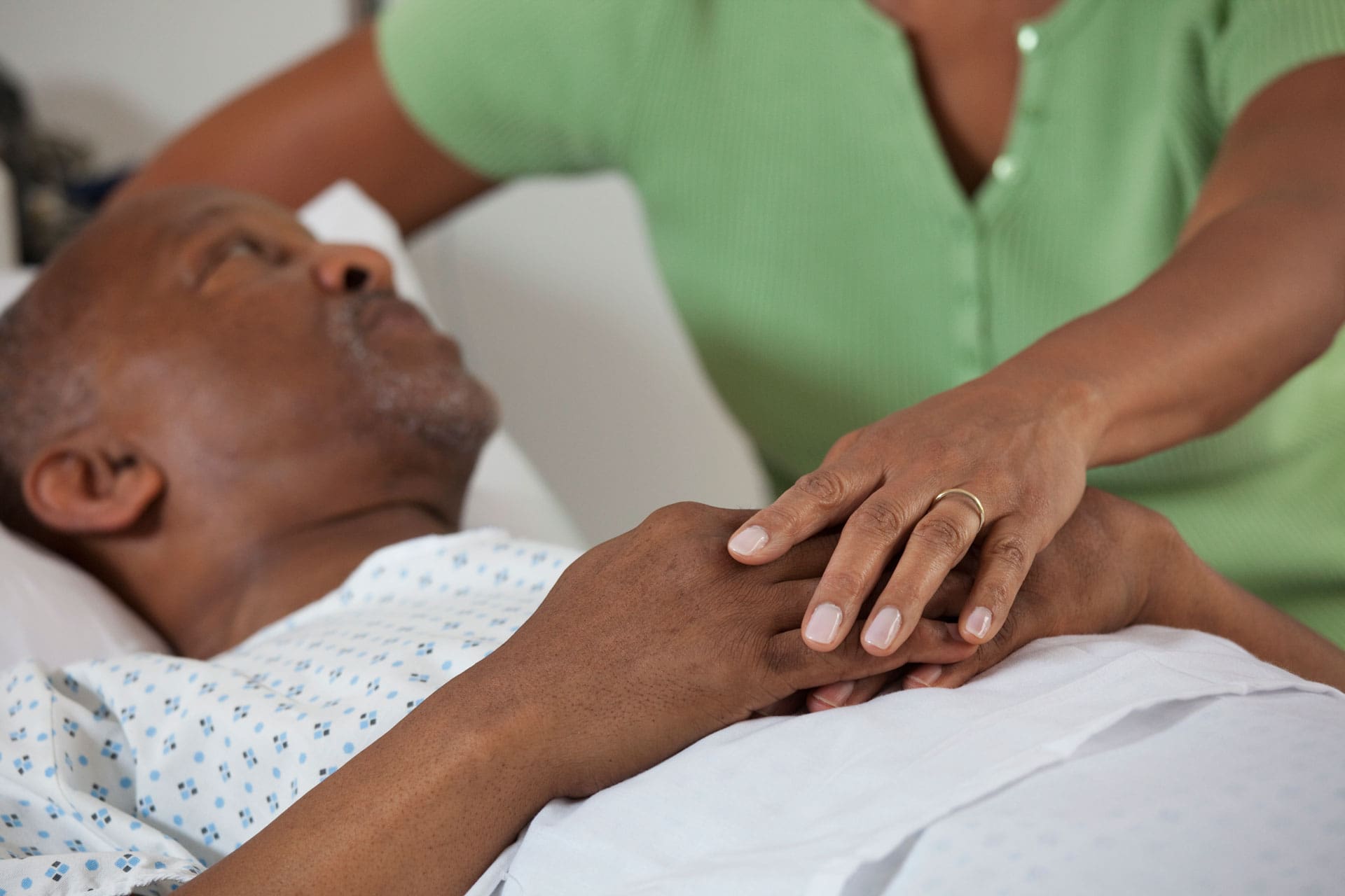 Caregiver patting hand of patient | TLC Your Way Hospice Care