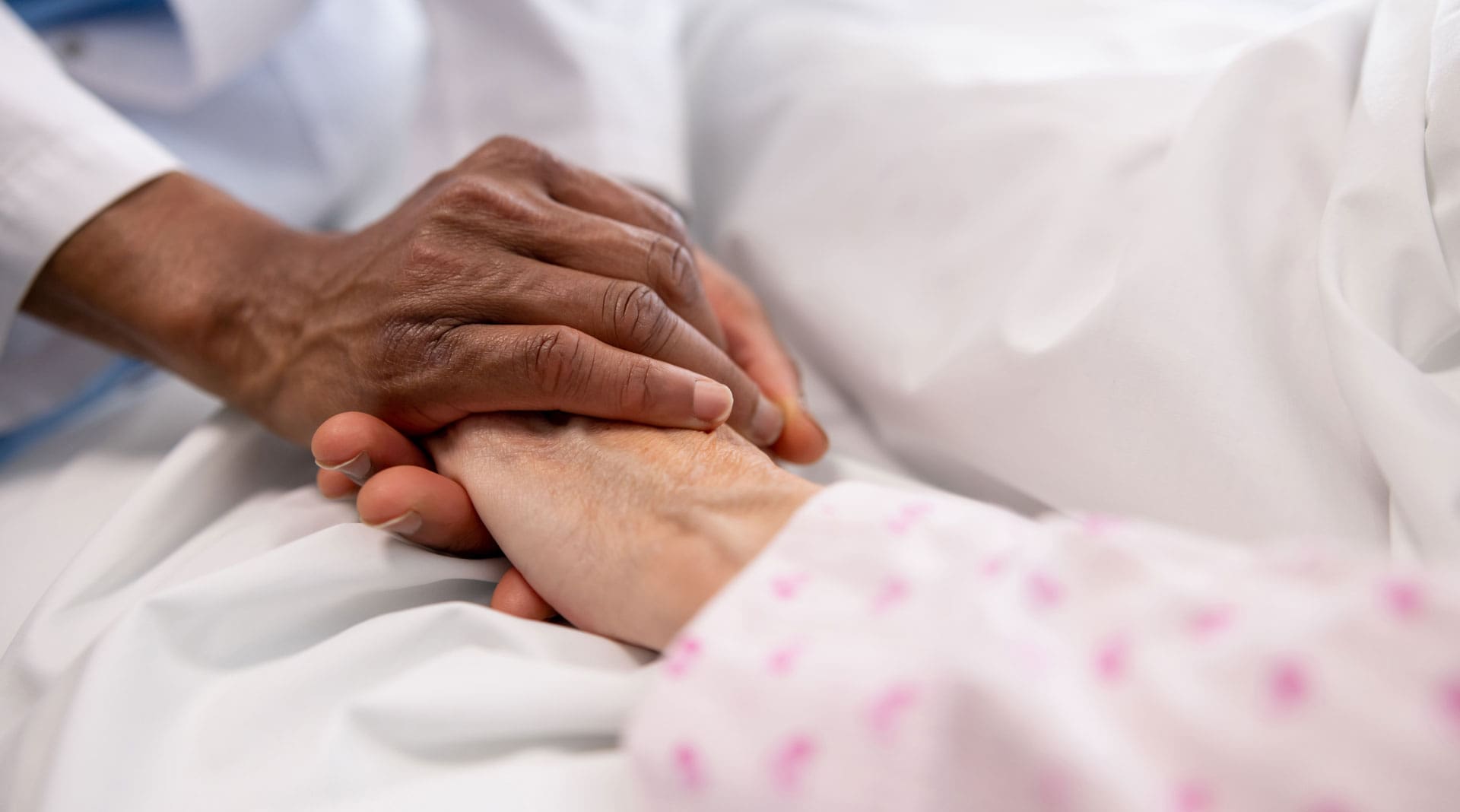 Caregiver holding patient's hand | TLC Your Way Hospice Care